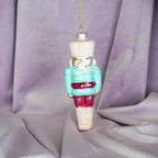 HOUSEVITAMIN KERSTHANGER NOTENKRAKER MET CUPCAKE GLAS BLAUW/ROOD 17 CM
